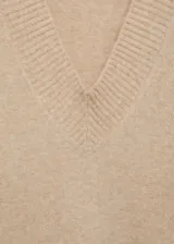 Sweater color beige de tejido de punto con cuello en V y corte oversize.