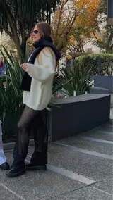 Conjunto de top y pantalón de hilo calado color negro. El top es corto con breteles finos y cierre frontal con lazos. El pantalón es de tiro alto y corte recto.