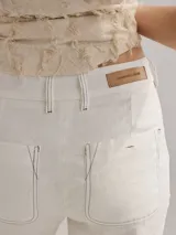 Pantalón cigarette color marrón claro, de lino, con bolsillos traseros y pinzas en la pierna trasera.