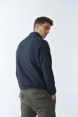 Buzo polar de algodón color bordó, con cuello elevado, medio cierre frontal, bolsillo con cierre en el pecho y logo estampado.