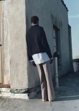 Pantalón de vestir marrón con estampado de cuadros pequeños, corte wideleg, tiro medio, bolsillos laterales y cierre frontal oculto con botón, gancho y cremallera.