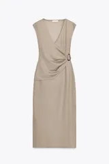 Vestido midi color beige, de corte recto, con escote en pico cruzado, sin mangas y detalle de hebilla metálica en la cintura.