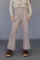 Pantalón acampanado con estampado a cuadros en tonos marrón, beige y rojo.