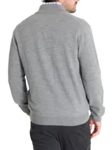 Sweater gris de lana merino extrafina, con cuello alto, cierre completo y bolsillos frontales.