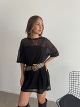 Conjunto de dos piezas: un vestido corto negro ajustado tipo strapless y un remerón negro de tul transparente con mangas cortas y cuello redondo superpuesto.