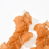 Aros colgantes marrones con forma de pétalos unidos por argollas doradas.
