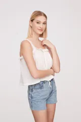 Musculosa color salmón con breteles finos y detalle de puntilla en el escote.