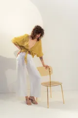 Blusa color mostaza de lino, con escote en V y mangas cortas abullonadas. Se ata en la parte delantera con dos cordones.