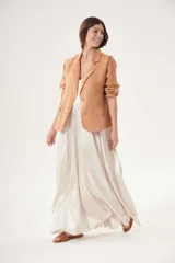 Blazer color beige de lino, con solapas de muesca, cierre con dos botones, bolsillos delanteros con solapa y corte clásico.