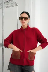 Campera tejida con textura vanizada a rayas horizontales en blanco y negro, con cierre frontal y flecos negros en forma de V en el pecho.