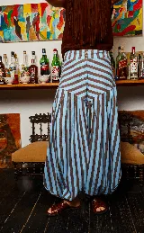 Pantalón babucha de lino con estampado a rayas verticales color celeste y marrón. Presenta corte amplio y tiras para atar en los tobillos.