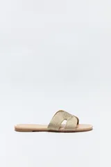 Sandalia baja negra con capellada trenzada tipo cordón, suela plana con bordado a tono.