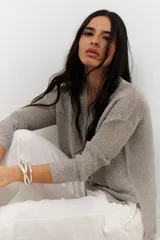 Sweater de tejido de punto fino con brillo metálico, color verde lima. Presenta escote en V y mangas largas.