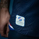 Camiseta de fútbol Umbro del Club Nacional de Football, modelo Away 2 2025. Diseño azul marino con patrón de ondas en azul oscuro, detalles en rojo, escudo bordado, sponsors oficiales y logo Nacional del Mundo en la nuca.