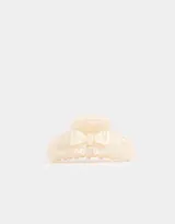 Broche para el pelo color crema con forma de pinza y detalle de moño.