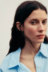 Vestido corto camisero celeste de algodón, con cuello solapa, manga larga con puños plisados, detalle de tablas en la falda y cierre frontal con botones.