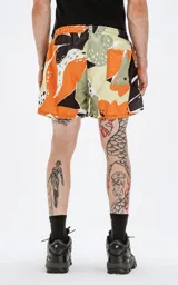 Short de baño con estampado abstracto en tonos naranja, marrón y beige.