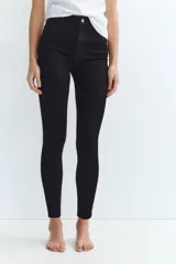 Jeans skinny de tiro alto en denim azul oscuro, con cinco bolsillos y cierre frontal con cremallera y botón metálico.