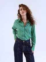 Camisa verde con rayas verticales azules, de corte cropped y manga larga.