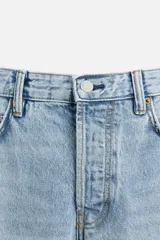 Pantalón de jean celeste de corte recto, con cinco bolsillos, efecto lavado y cierre frontal con botones.