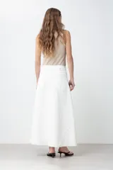 Maxi falda blanca de jean con corte evasé, cintura alta y cierre frontal con cremallera.