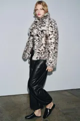 Pantalón bombacho negro de tiro medio, confeccionado en tejido efecto piel, con cintura elástica, bolsillos laterales ocultos y bajo abullonado con elástico.