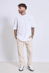 Remera blanca de corte holgado con pequeño estampado en el pecho.