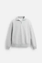 Sudadera gris de cuello alto con cierre frontal de cremallera, manga larga y corte relaxed fit.