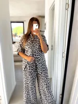 Conjunto de camisa de manga corta y pantalón palazzo acampanado con estampado de leopardo en tonos blanco, gris y negro.