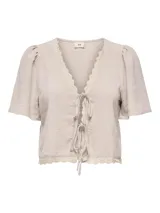 Blusa color gris claro con escote en V, mangas cortas abullonadas y detalle de encaje en el escote y ruedo. Se cierra con lazos en el frente.
