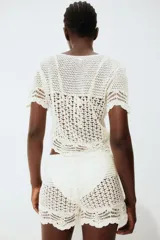 Short de playa tejido al crochet color blanco, con cintura elástica y cordón de ajuste.