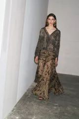 Falda midi de tiro alto con estampado paisley en tonos marrones y dorados. Presenta cintura con drapeado lateral y bajo asimétrico evasé. Cierre con cremallera oculta en la costura.