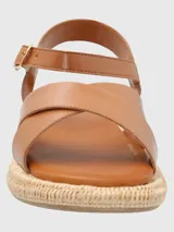Sandalias Concetta de cuero color marrón claro, con tiras cruzadas y ajuste con hebilla en el tobillo. Plataforma con base tejida tipo esparto y plantilla acolchada.