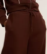 Pantalón de corte recto color marrón con raya lateral blanca y lazo en la cintura.