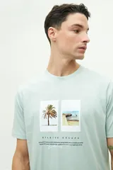 Remera verde agua de manga corta con estampado de dos fotografías en el frente.