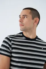 Remera de algodón a rayas horizontales en tonos blanco, marrón y rojo. Tiene cuello redondo, mangas cortas, corte regular y logo estampado en el pecho.