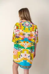 Camisa color crema con estampado de palmeras rosas, de corte recto y manga corta.