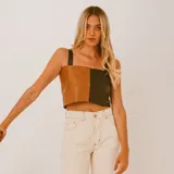Top corto de cuero con diseño color block en marrón y negro, breteles anchos y corte ajustado.