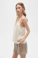 Musculosa color crema de bretel fino con apliques de cadena en los breteles y escote en V.