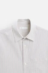 Camisa de hombre relaxed fit confeccionada en tejido de algodón a cuadros. Tiene cuello solapa, manga larga con puños abotonados, bolsillo en el pecho y cierre frontal con botones.