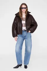 Chaqueta de cuero sintético color marrón chocolate, con diseño oversize, cuello alto tipo funnel, cierre frontal oculto y mangas dolman con puños fruncidos.