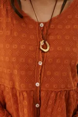 Camisa blanca con bordado floral, cuello en V y cierre frontal con botones.