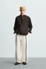 Pantalón de lino color crudo con rayas verticales negras, corte relaxed fit, cintura elástica ajustable con cordón, bolsillos laterales y traseros.