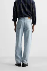 Pantalón de jean celeste de corte recto, con cinco bolsillos, efecto lavado y cierre frontal con botones.