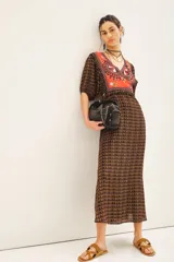 Vestido largo de viscosa estampada, con escote en V, mangas cortas con frunces y elástico en los puños, bordados en el delantero y la espalda, cintura con elástico y cierre lateral con gancho invisible.