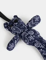 Llavero con forma de oso de peluche azul marino con estampado paisley blanco y cinta de agarre negra.