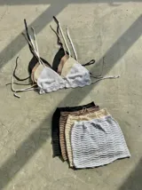 Conjunto de top halter tejido al crochet con volados en el ruedo y mini falda tejida al crochet.