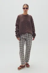 Pantalón de vestir de corte recto con estampado de cuadros escoceses en tonos grises, blancos y marrones.