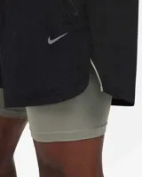 Short de running Nike Running Division, color negro, con short interior gris. Cuenta con tecnología Dri-FIT, tejido Ripstop repelente al agua, bolsillos laterales y trasero con cremallera, y bolsillo interior.