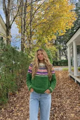 Sweater de lana merino color crema con cuello alto y diseño con motivos geométricos en amarillo, naranja, violeta y negro.